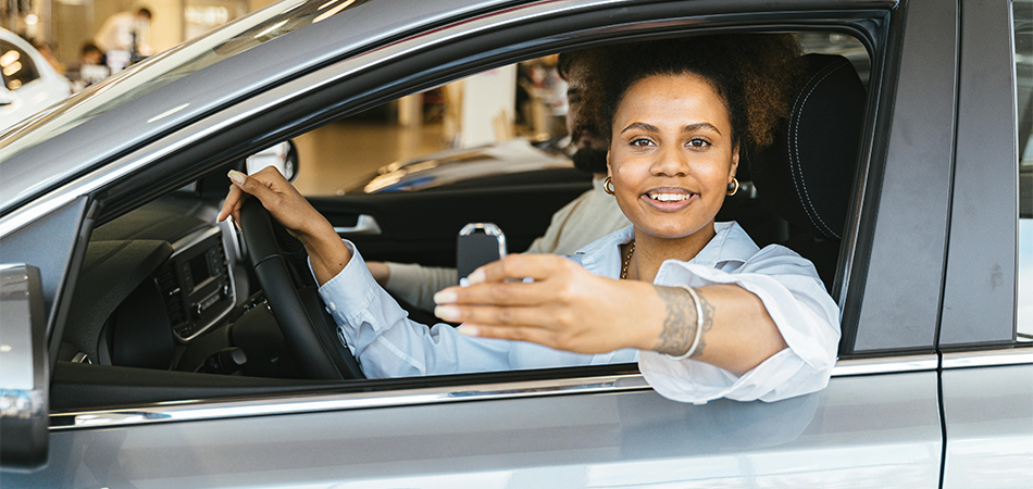 Lady sitting in her car holding a key